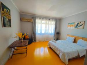 1 dormitorio con cama, mesa y ventana en Gallivanters Hostel, en Dar es Salaam