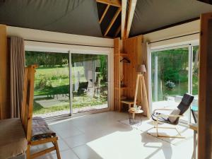 a living room with large windows and a chair at Villa 2008 in Chichée
