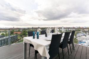 a table on a balcony with a view of a marina at Penthouse with amazing views of Copenhagen! in Copenhagen