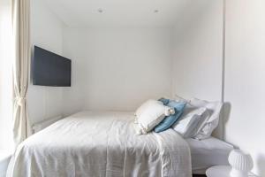 a white bedroom with a bed and a tv at Penthouse with amazing views of Copenhagen! in Copenhagen