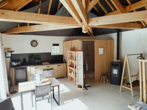 a kitchen with wooden ceilings and a table and chairs at Villa 2008 in Chichée