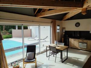 a kitchen with a table and chairs and a pool at Villa 2008 in Chichée +15 photos