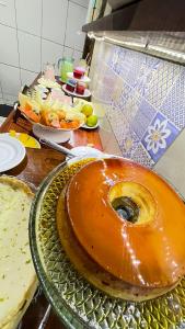 a large doughnut sitting on a glass plate on a table at Pousada Cores Do Mar in Paraty