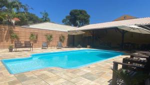 Casa Do Armando في غواراتوبا: مسبح في ساحة فيها مظلة