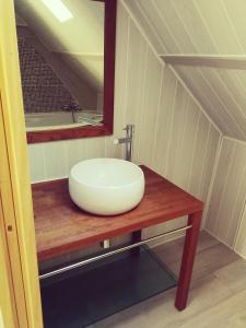um lavatório branco num balcão de madeira na casa de banho em AU BON CAUCHOIS em Anglesqueville-lʼ Esneval