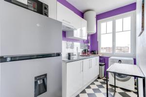 een witte keuken met paarse muren en een geruite vloer bij Chic apart Paris - La defense in Courbevoie