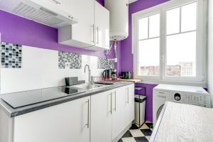 een keuken met witte kasten en paarse muren bij Chic apart Paris - La defense in Courbevoie