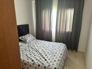 a bedroom with a bed and a window with curtains at Mirage Appart Tangier in Tangier