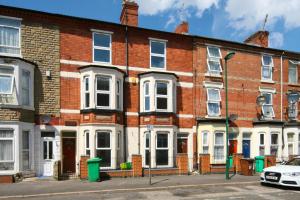 a row of brick houses on a street at St Michael's House - Urban Oasis Townhouse in Nottingham