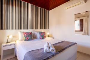 1 dormitorio con 1 cama con toallas en Pousada Recanto do Jabaquara, en Paraty
