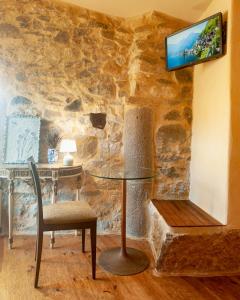 a room with a table and a chair and a tv on a wall at Chapim Azul Studio in Cabrela