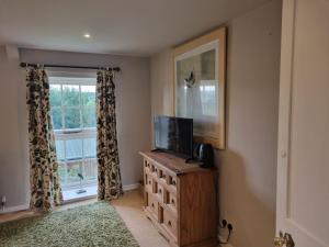 a living room with a tv and a window at Coves House Farm B&B in Wolsingham
