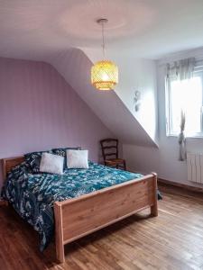 a bedroom with a bed with a blue comforter at Maison d'hôte de l'Aber - Lavande in Crozon