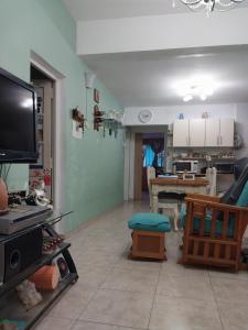 a living room with a tv and a kitchen at Lollapalooza muy cerca in San Isidro