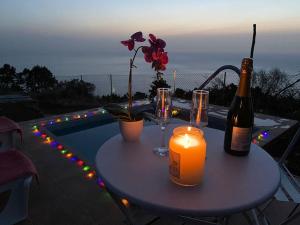 a table with a candle and two bottles and glasses at helios casa vacacional in Puntagorda