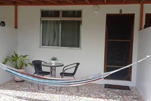 a hammock in a patio with a table and chairs at Casa em Condomínio tranquilo bem perto da praia! in Saquarema