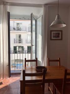 a dining room table with a view of a balcony at Apartament Riera in Cadaqués