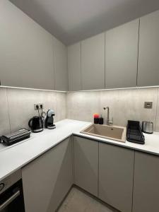 a kitchen with white cabinets and a sink at Oculus Kolonaki Apt in Athens