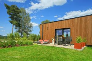 een houten gebouw met een tafel en stoelen in een tuin bij Gîte Altitude 399 à Trois-Ponts in Basse-Bodeux