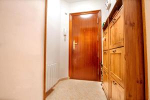 a hallway with a wooden door and a mirror at Apartamento en Laredo in Laredo