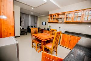 a kitchen with a wooden table and chairs at Snow View Rau Apartments in Moshi