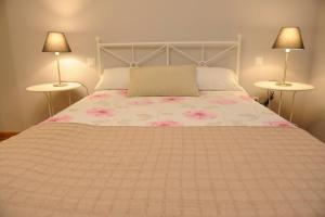 a bedroom with a bed with pink flowers on it at Apartamento Museo de Bellas Artes in Seville