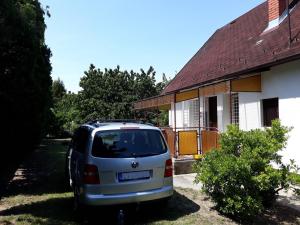 una furgoneta blanca estacionada frente a una casa en Szilva Apartman en Fertőhomok