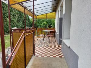 een balkon met een tafel en stoelen op een patio bij Szilva Apartman in Fertőhomok