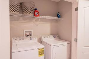 uma lavandaria com máquina de lavar e secar roupa em 3BD Townhouse , Themed , 10 min to Disney , Gated em Kissimmee