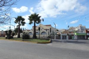 un edificio con palme di fronte a una strada di Departamentos centro Valle Hermoso a Valle Hermoso