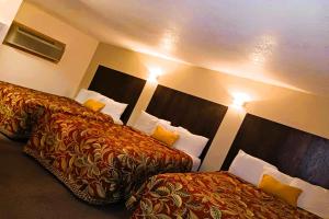 una camera d'albergo con due letti e una testiera di HomeTown Inn By OYO Lakin, KS a Lakin