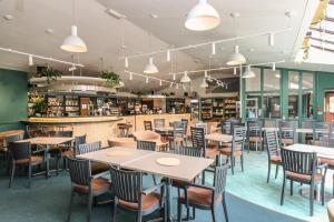 Un restaurante con mesas y sillas y un bar. en Robinswood, en Falmouth