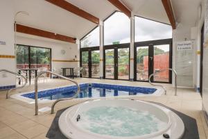 Una gran piscina con jacuzzi en un edificio. en Robinswood, en Falmouth