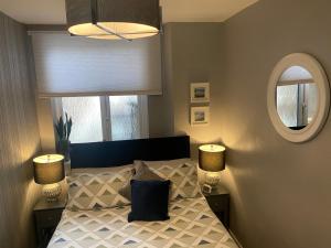 a bedroom with a bed with two lamps and a mirror at Grand View in North Shields