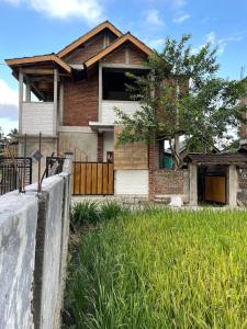 a brick house with a fence in front of it at MyHome - Lombok in Tetebatu