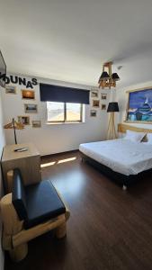 una camera con un letto e una sedia di Atlantic Spot Guest House a Praia de Mira