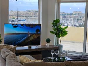 a living room with a couch and a flat screen tv at MIVE Luxury Sea View Penthouse in Il-Gżira