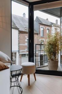 Habitación con mesa, silla y ventana en Chimay : La Chambre Blanche de la Grand Place, en Chimay