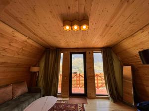a living room with a couch and two windows at Cabin 32 in Kazbegi