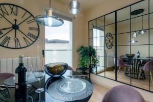 comedor con reloj, mesa y sillas en La Quinta Esencia by Unique Rooms, en Burgos
