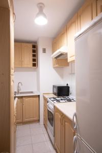 a kitchen with wooden cabinets and a stove top oven at ClickTheFlat Pereca City Centre Apart Rooms in Warsaw