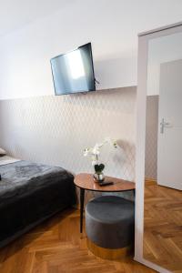 a bedroom with a bed and a table with a tv on the wall at ClickTheFlat Pereca City Centre Apart Rooms in Warsaw