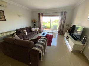 a living room with a couch and a flat screen tv at Beautiful 2 bed townhouse on Boavista golf course in Lagos