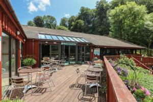 a wooden deck with chairs and tables on a building at Owls Roost in Falmouth