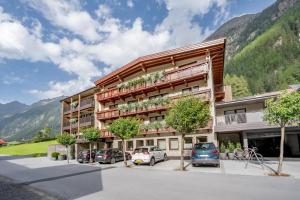 a building with cars parked in a parking lot at rechenau LIVING & RELAX in Sölden