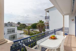 a balcony with a white table and chairs and a view at Quinta Pedra dos Bicos By Albufeira Rental in Albufeira