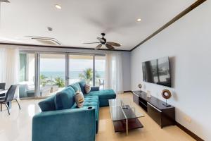 a living room with a blue couch and a tv at Diamante del Sol, Unit 402N in Jacó