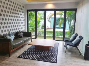 a living room with a couch and a coffee table at E villa near bangtao beach ,普吉高端社区邦涛区度假村私人泳池别墅 in Bang Tao Beach