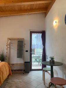 1 dormitorio con cama, mesa y patio en Valtellina Grosotto Holidays, en Grosotto