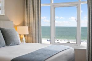 una camera da letto con una grande finestra con vista sull'oceano di Marco Beach Ocean Suites a Marco Island